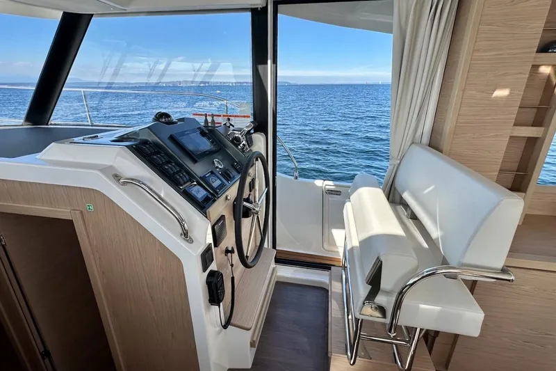 Slide: The Image of 2024 Beneteau Swift Trawler 41 Sedan helm with ocean view and modern controls. - 57