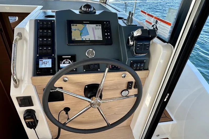Slide: The Image of Helm of 2024 Beneteau Swift Trawler 41 Sedan with navigation controls and steering wheel. - 58