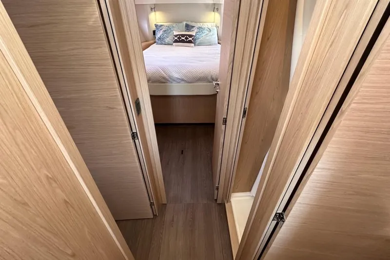 Slide: The Image of Interior hallway of 2024 Beneteau Swift Trawler 41 Sedan, featuring wood paneling and cozy bedroom. - 61