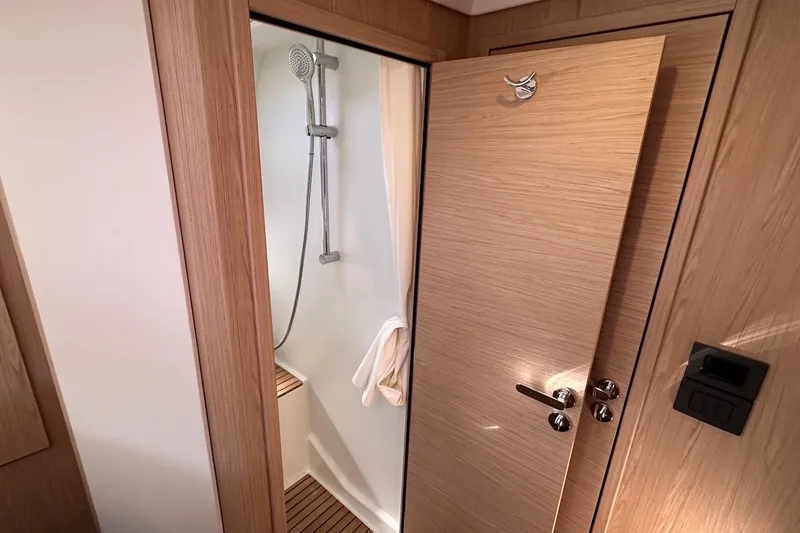 Slide: The Image of 2024 Beneteau Swift Trawler 41 Sedan bathroom with wooden door and modern shower. - 67