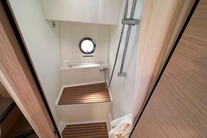 Slide: The Image of 2024 Beneteau Swift Trawler 41 Sedan shower with wooden flooring and porthole window. - 68