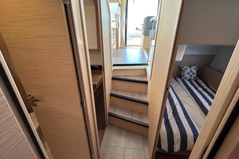 Slide: The Image of 2024 Beneteau Swift Trawler 41 Sedan interior with cozy cabin and striped bedding. - 70