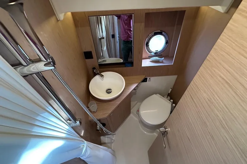 Slide: The Image of 2024 Beneteau Swift Trawler 41 Sedan bathroom with modern fixtures and porthole window. - 72