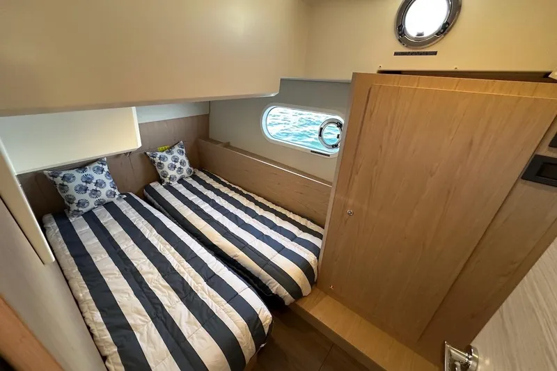 Slide: The Image of 2024 Beneteau Swift Trawler 41 Sedan cabin with twin beds and nautical decor. - 73