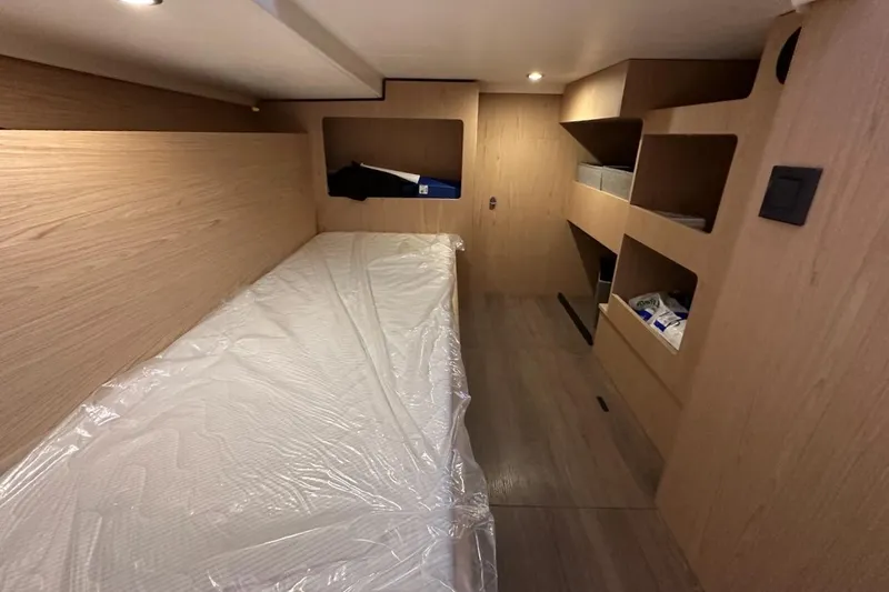 Slide: The Image of 2024 Beneteau Swift Trawler 41 Sedan cabin interior with wooden finish and storage shelves. - 78