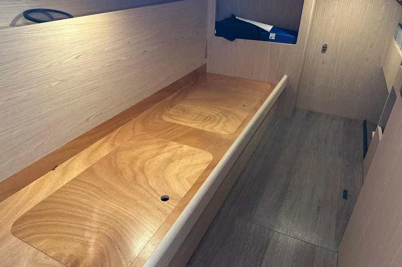 Slide: The Image of Interior of 2024 Beneteau Swift Trawler 41 Sedan, featuring sleek wooden finishes and storage space. - 79
