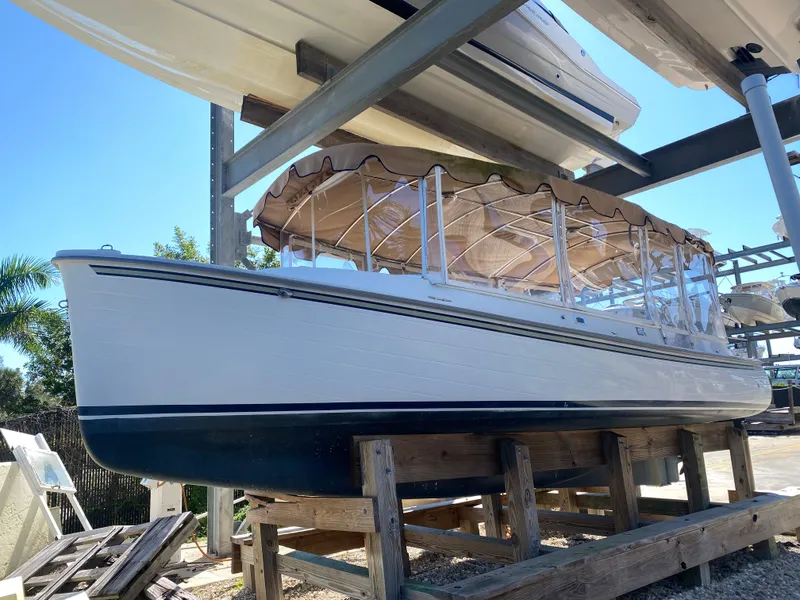 Slide: The Image of 2017 Duffy 22 electric boat on wooden stand outdoors. - 2