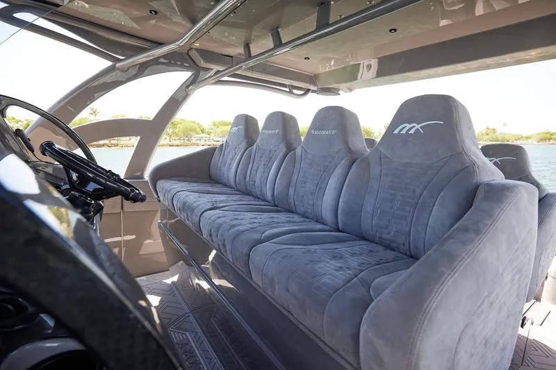 Slide: The Image of Luxurious seating inside a Midnight Express 52 Vitesse boat, featuring plush gray upholstery. - 16