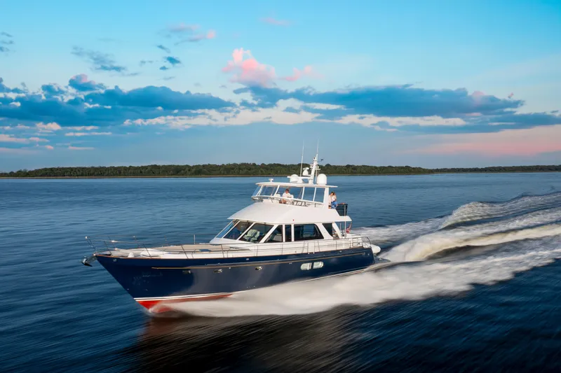 The Image of 2027 Hunt Yachts 63 Flybridge cruising on serene waters at sunset. - 0