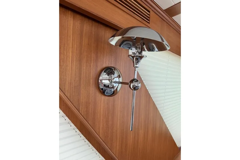 Slide: The Image of Chrome wall lamp on Hunt Yachts 63 Flybridge, 2027 model, with wooden panel background. - 10