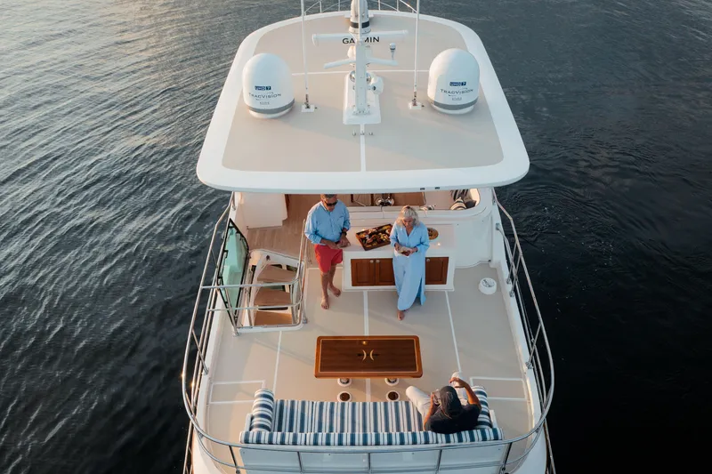 Slide: The Image of Aerial view of 2027 Hunt Yachts 63 Flybridge with people enjoying the deck. - 16