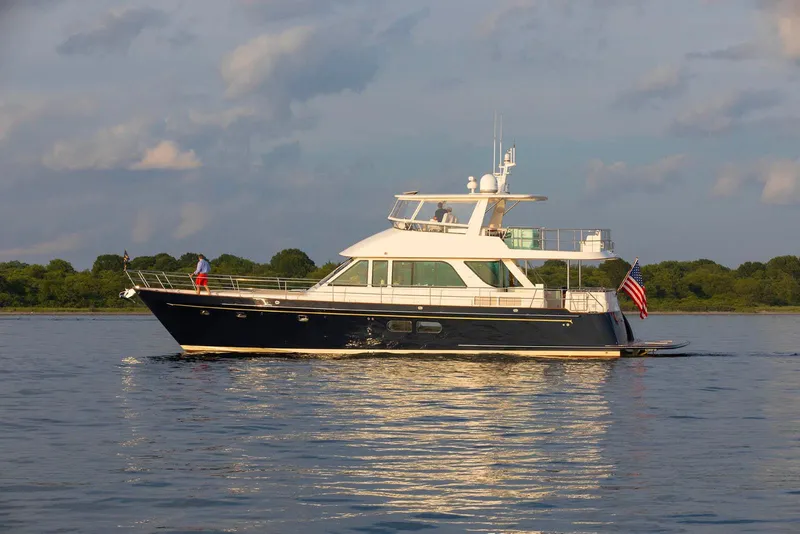 Slide: The Image of 2027 Hunt Yachts 63 Flybridge cruising on calm waters with scenic background. - 18