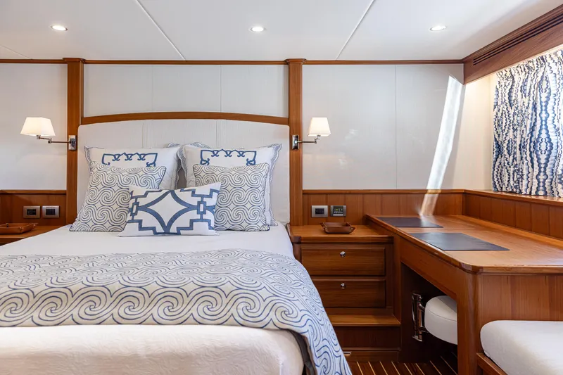 Slide: The Image of Luxurious cabin interior of 2027 Hunt Yachts 63 Flybridge with elegant bedding and wooden furnishings. - 4