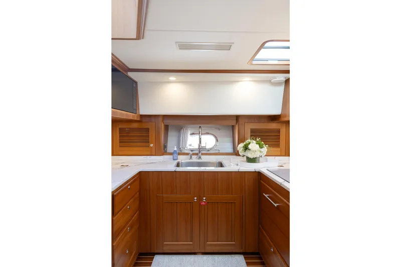 Slide: The Image of Luxurious kitchen interior of 2027 Hunt Yachts 63 Flybridge with wood cabinetry and modern fixtures. - 8