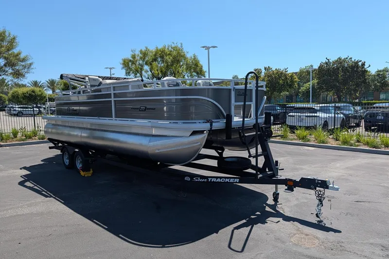 Slide: The Image of 2026 Sun Tracker Fishin' Barge 22 DLX pontoon boat on trailer in parking lot. - 3