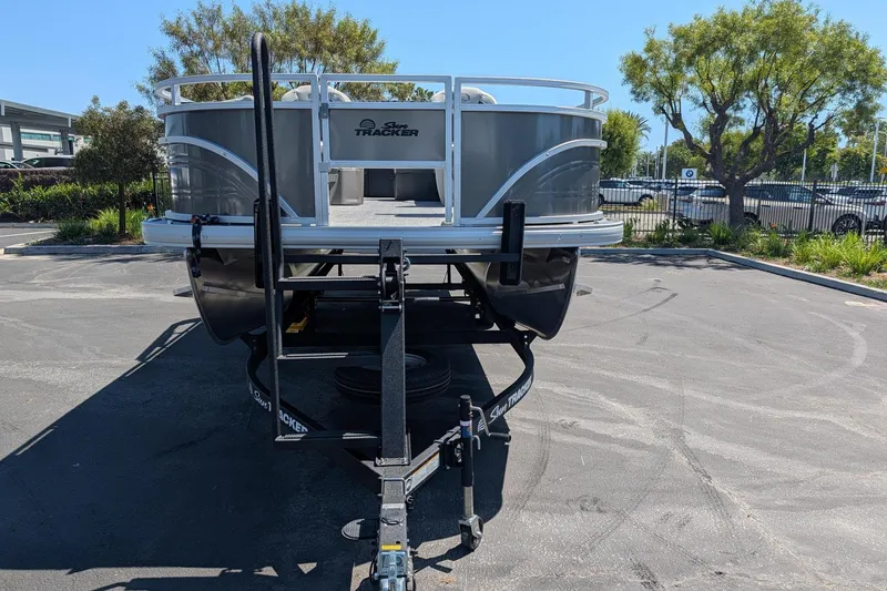Slide: The Image of 2026 Sun Tracker Fishin' Barge 22 DLX pontoon boat on trailer in parking lot. - 5
