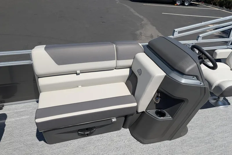 Slide: The Image of 2026 Sun Tracker Fishin' Barge 22 DLX interior with gray seating and steering console. - 7