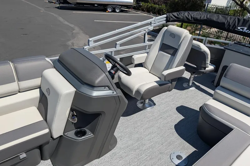 Slide: The Image of 2026 Sun Tracker Fishin' Barge 22 DLX interior with comfortable seating and steering console. - 8