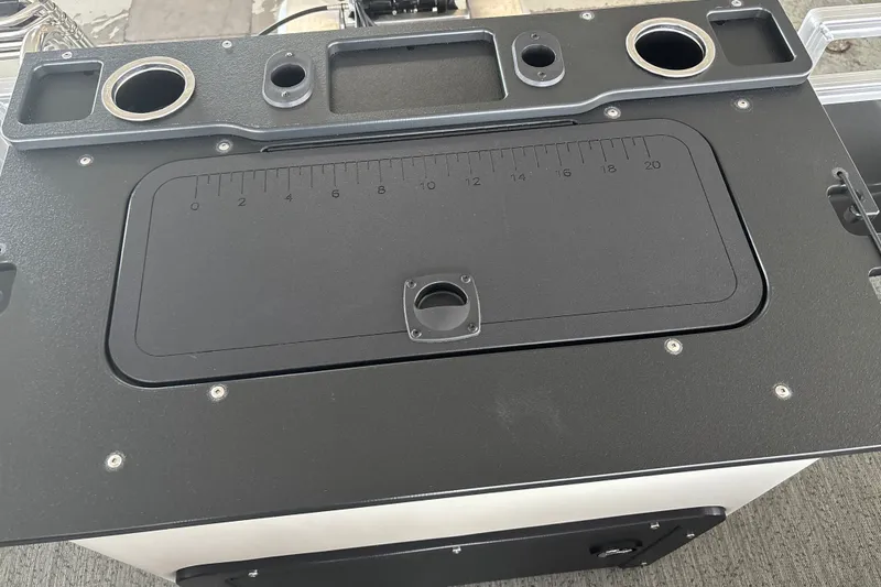 Slide: The Image of 2026 Sun Tracker Fishin' Barge 22 DLX console with cup holders and measurement markings. - 37