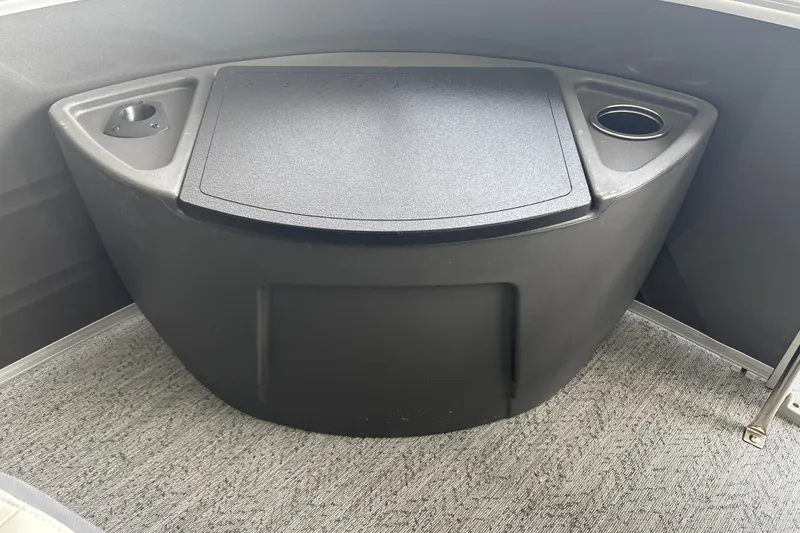 Slide: The Image of 2026 Sun Tracker Fishin' Barge 22 DLX storage compartment with cup holders. - 24