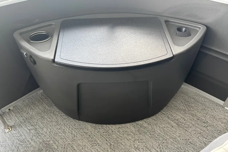 Slide: The Image of Interior view of 2026 Sun Tracker Fishin' Barge 22 DLX with storage compartment and cup holders. - 25