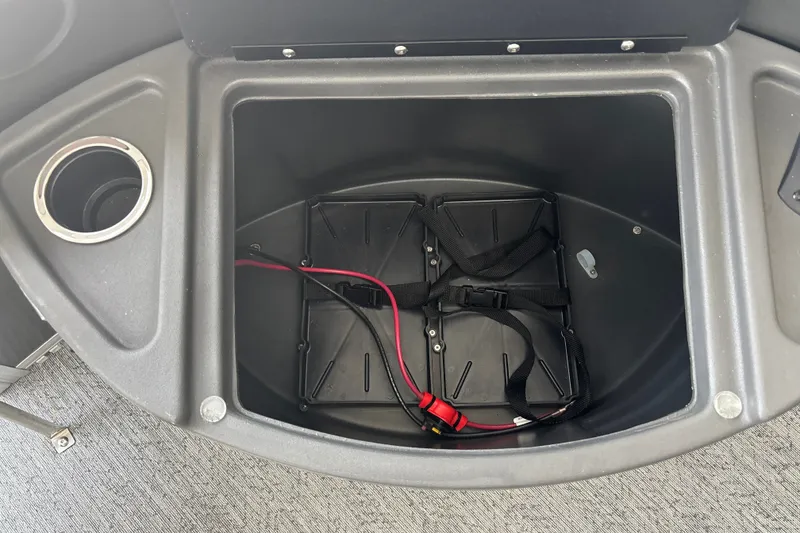 Slide: The Image of Storage compartment of 2026 Sun Tracker Fishin' Barge 22 DLX with cup holder and wiring. - 26
