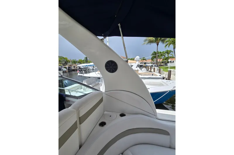 Slide: The Image of Interior view of a 2006 Sea Ray Sundancer 320 yacht, featuring white seating and marina backdrop. - 10