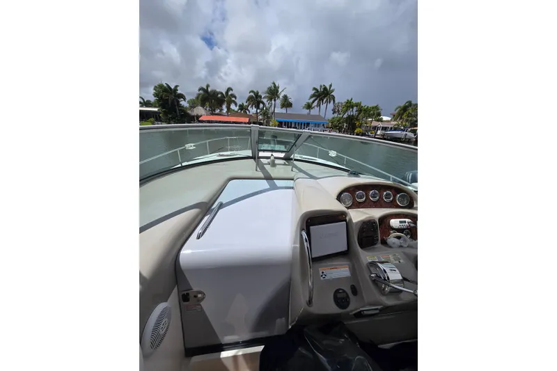 Slide: The Image of 2006 Sea Ray Sundancer 320 helm with palm trees and cloudy sky in background. - 14
