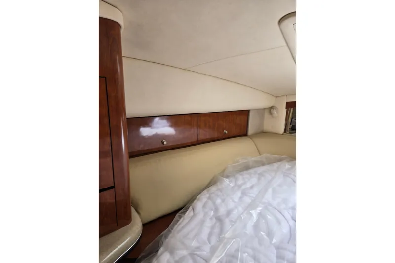 Slide: The Image of Interior cabin of 2006 Sea Ray Sundancer 320 with wood paneling and beige upholstery. - 18