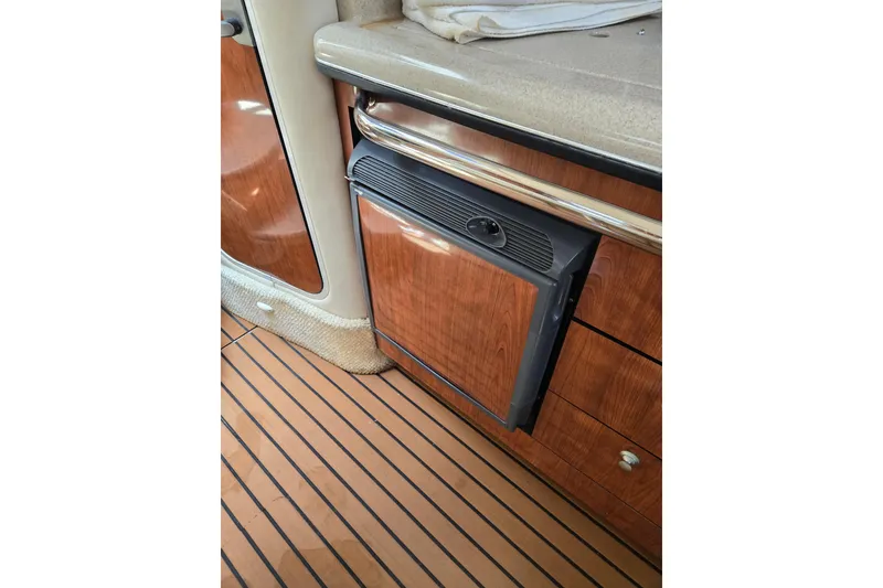 Slide: The Image of 2006 Sea Ray Sundancer 320 interior with wood cabinetry and compact refrigerator. - 22