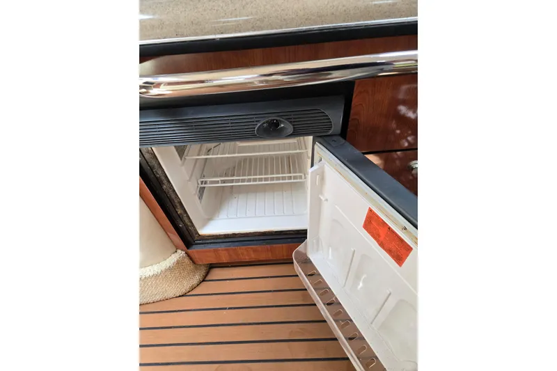 Slide: The Image of Open mini fridge on 2006 Sea Ray Sundancer 320 boat with wooden flooring. - 23