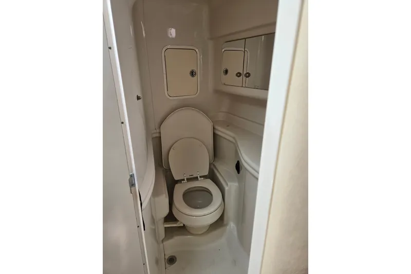 Slide: The Image of Compact bathroom in 2006 Sea Ray Sundancer 320 yacht, featuring toilet and storage cabinets. - 25