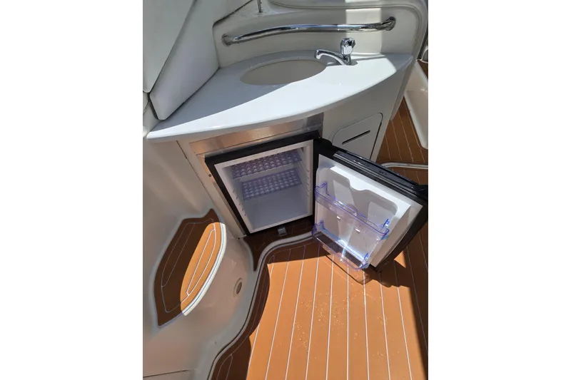 Slide: The Image of 2006 Sea Ray Sundancer 320 interior with open mini fridge and sink. - 8