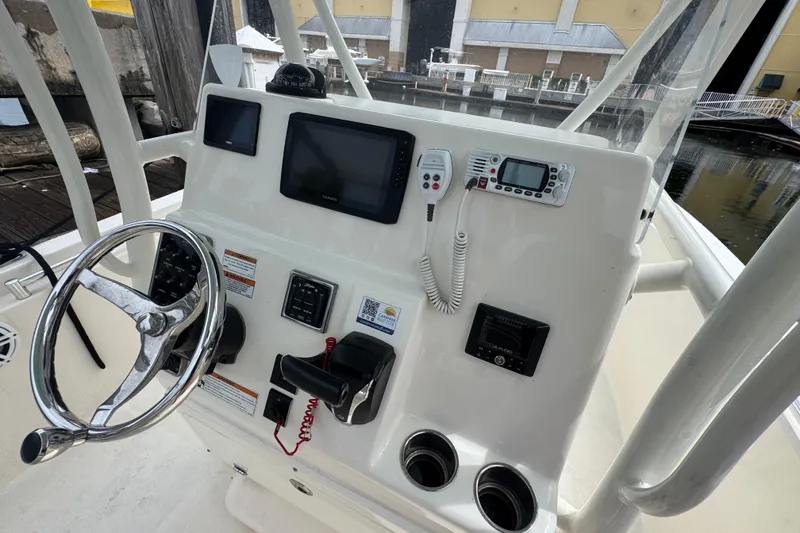 Slide: The Image of 2021 Cobia 237 Center Console boat dashboard with steering wheel and electronic controls. - 14