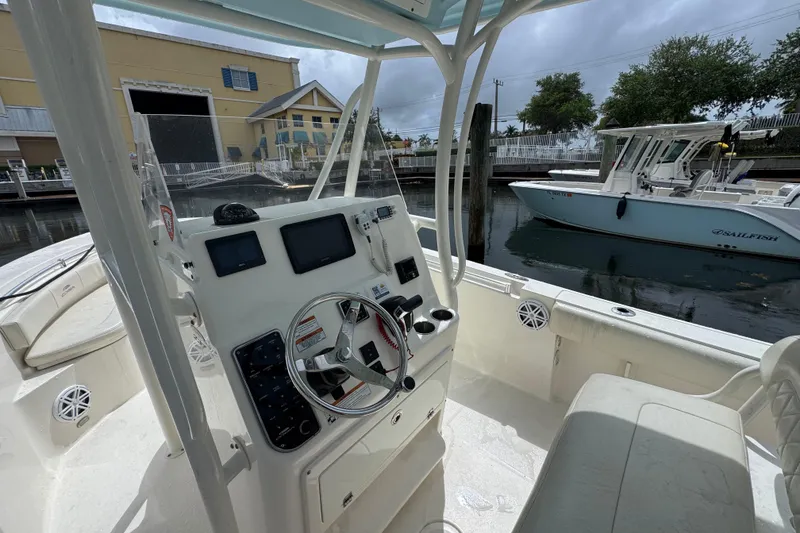 Slide: The Image of 2021 Cobia 237 Center Console boat interior with steering wheel and navigation equipment. - 15