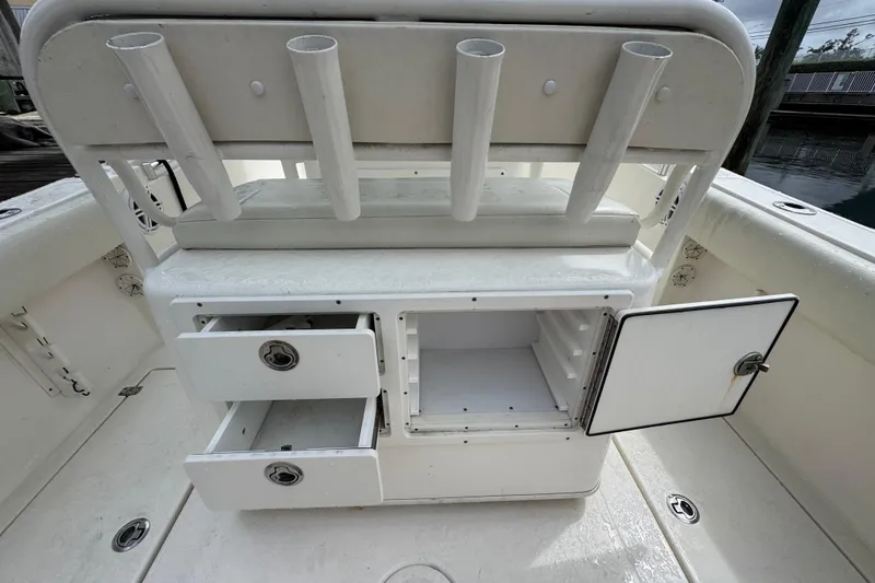 Slide: The Image of 2021 Cobia 237 Center Console boat storage with open compartments and rod holders. - 16