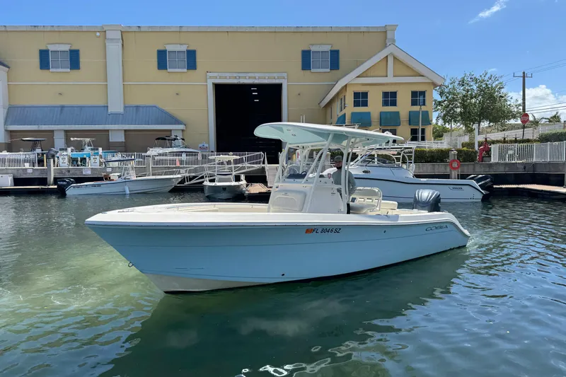 Slide: The Image of 2021 Cobia 237 Center Console boat docked near a marina building. - 4