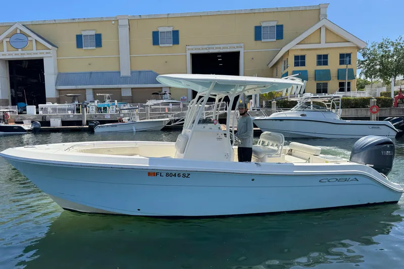 Slide: The Image of 2021 Cobia 237 Center Console boat docked at marina with Yamaha engine. - 5