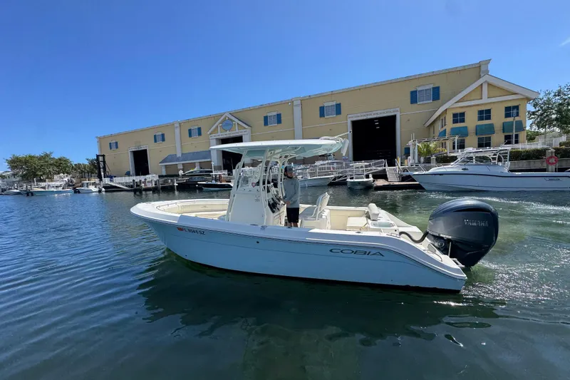 Slide: The Image of 2021 Cobia 237 Center Console boat docked near a marina building. - 6
