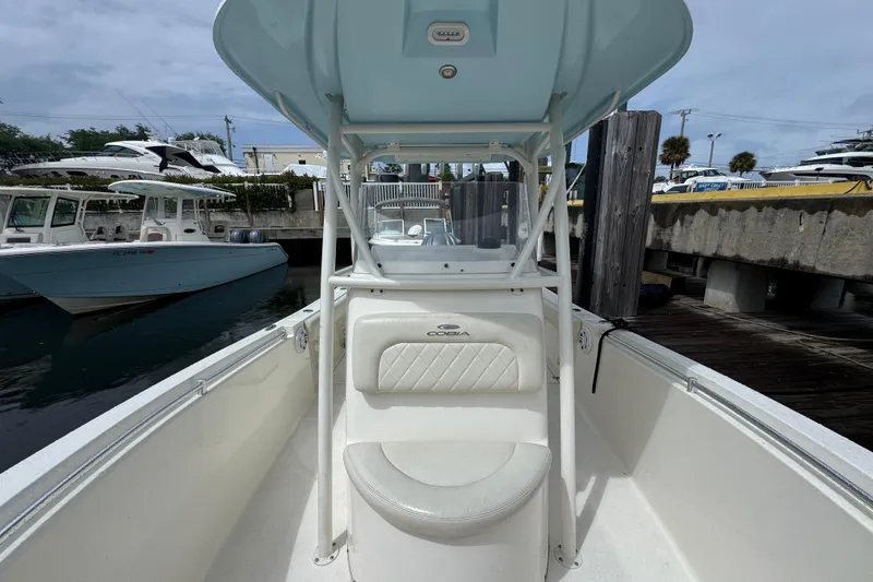Slide: The Image of 2021 Cobia 237 Center Console boat docked at marina under cloudy sky. - 8