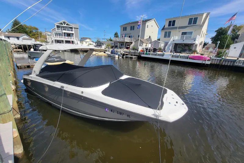 The Image of 2018 Regal 26 OBX boat docked in a residential canal setting. - 0