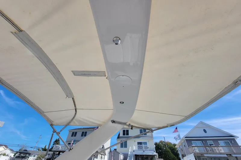 Slide: The Image of 2018 Regal 26 OBX boat canopy with residential background and clear blue sky. - 10