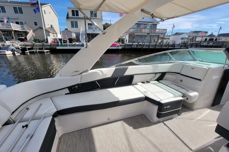 Slide: The Image of 2018 Regal 26 OBX boat interior with white seating, dockside view. - 8