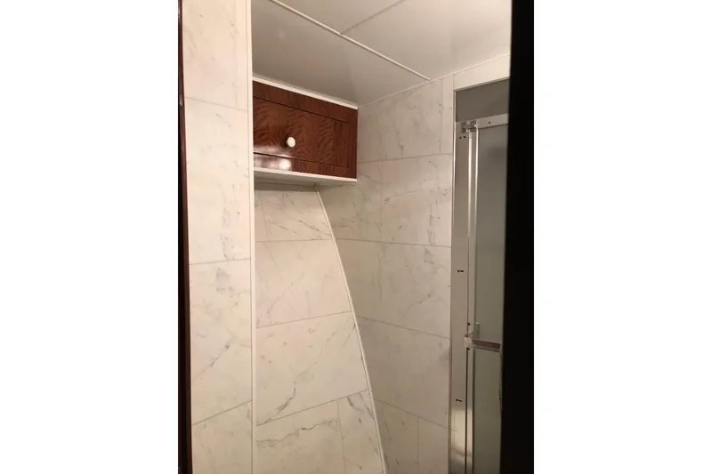 Slide: The Image of 1976 Hatteras 53 Convertible yacht bathroom with marble walls and wooden cabinet. - 13