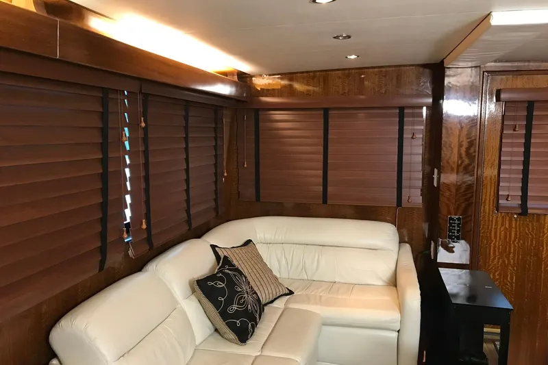 Slide: The Image of Interior of 1976 Hatteras 53 Convertible yacht with white leather seating and wooden blinds. - 2