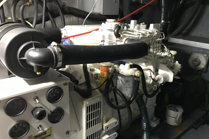 Slide: The Image of Engine room of a 1976 Hatteras 53 Convertible yacht, showcasing mechanical components and controls. - 24