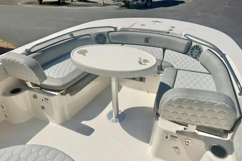Slide: The Image of 2026 Carolina Skiff 21 Ultra Elite boat interior with cushioned seating and round table. - 11