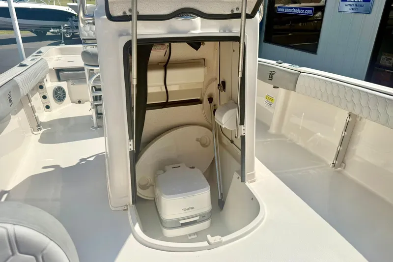 Slide: The Image of 2026 Carolina Skiff 21 Ultra Elite boat interior with compact toilet and storage area. - 19