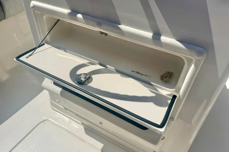 Slide: The Image of Storage compartment on a 2026 Carolina Skiff 21 Ultra Elite boat, open and sunlit. - 25