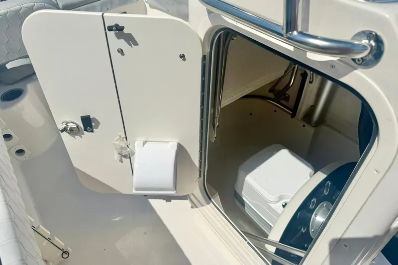 Slide: The Image of 2026 Carolina Skiff 21 Ultra Elite boat interior with storage compartment and toilet. - 27